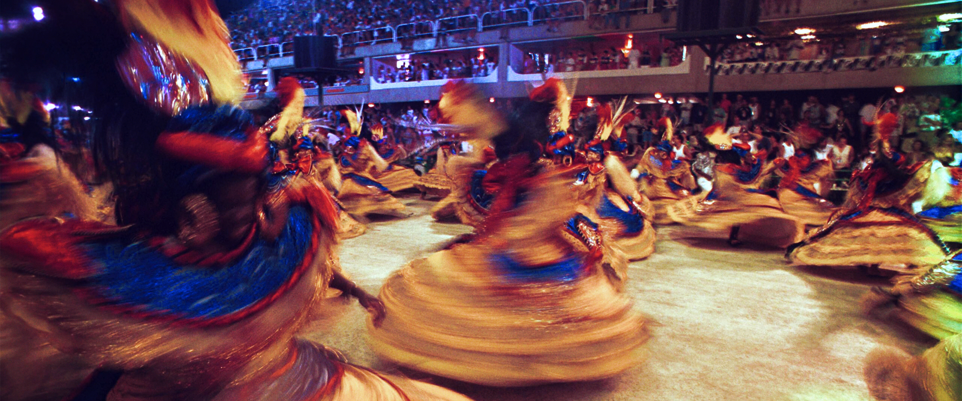 A imagem mostra mulheres de uma escola de samba desfilando no Carnaval.